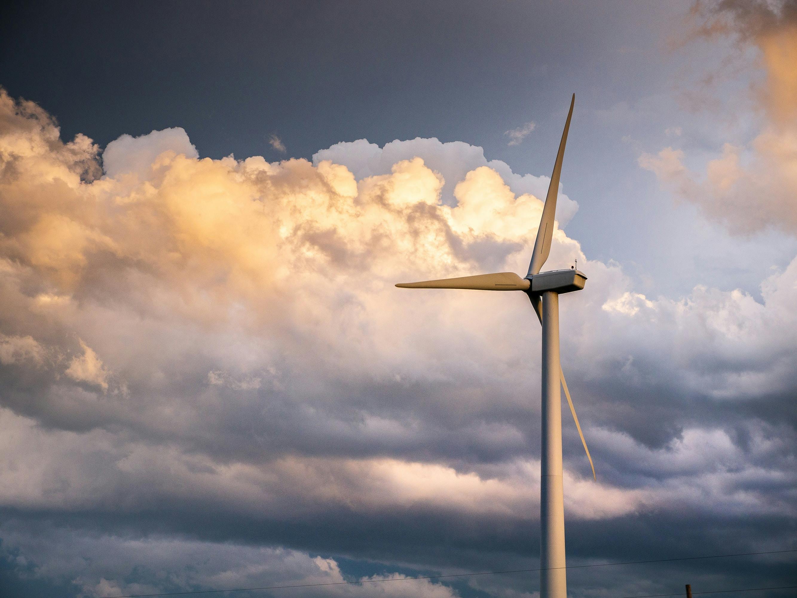 The photo depicts a wind turbine set against a stormy Oklahoma sky.