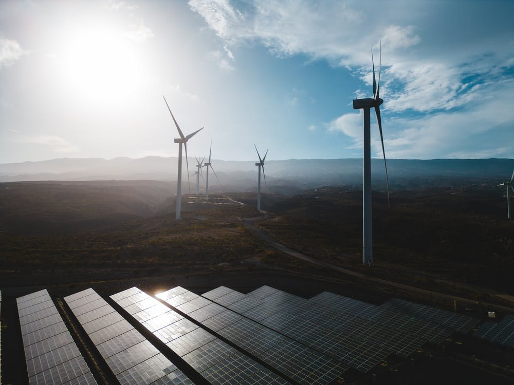 Investment Topic Page Cover Image Windwills In The Background With Solar Panels At The Foreground