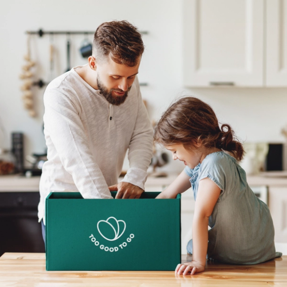 a man and a little girl are looking into a box that says too good to go