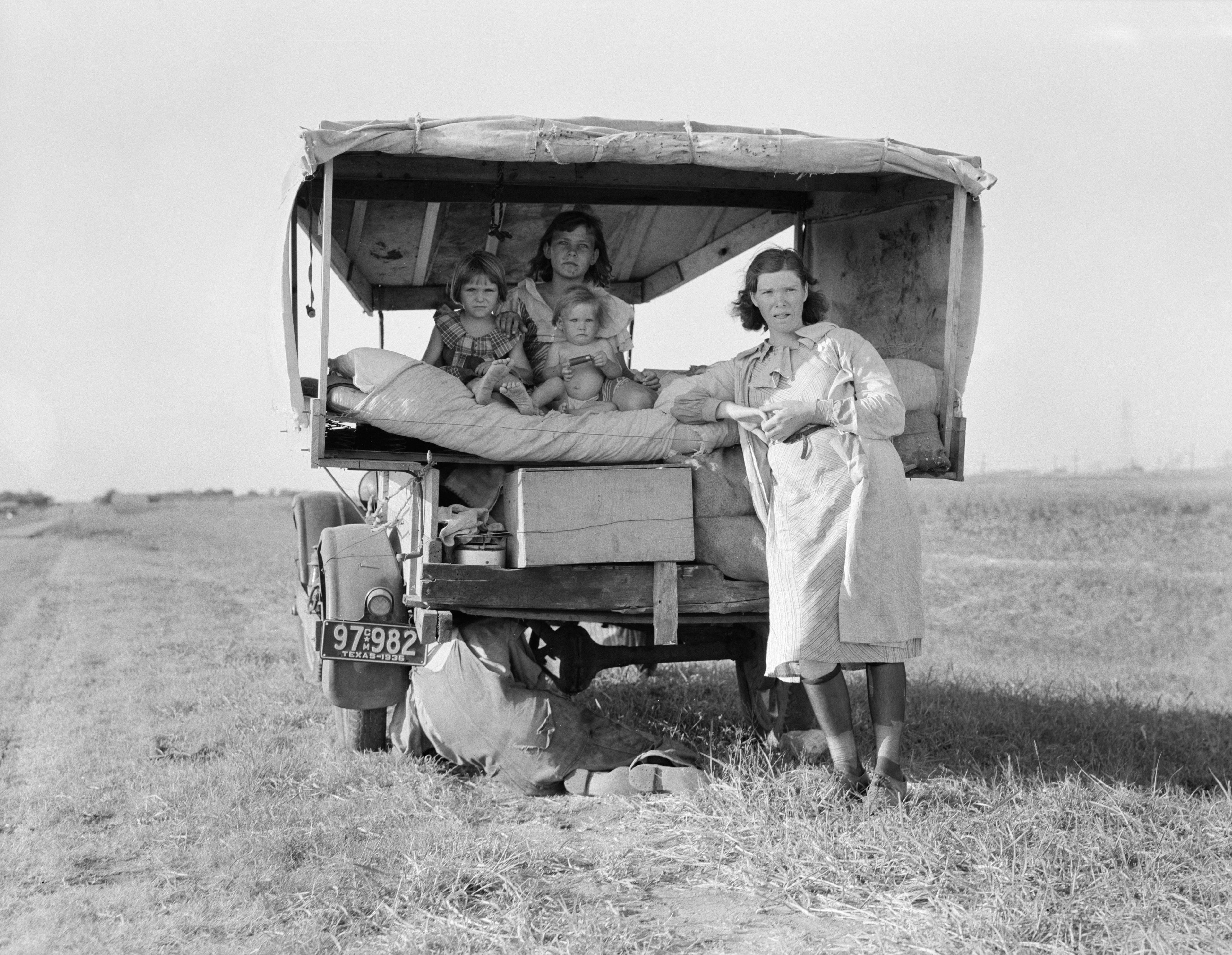 Migrant Family Heading to Arkansas Delta for Work in Cotton Fields, with Flat Tire, Texas, USA, Dorothea Lange for Farm Security Administration, August 1936. (Photo by: Universal History Archive/Universal Images Group via Getty Images)