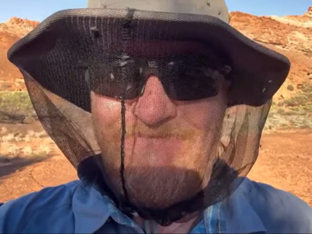 <p>A man wears a net hat for protection from bush flies</p>