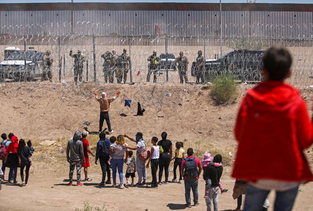<p>Migrants on the Mexican side of the US-Mexico border engage in a confrontation with Texas National Guard troops on May 13, 2024 </p>
