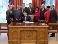 President Barack Obama signs the White House Initiative on Educational Excellence for African Americans Executive Order in the Oval Office, July 26, 2012