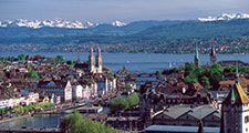 The twin spires of the Grossmunster are a distinctive feature of Zurich's cityscape: the popular panoramic view shows Zurich Downtown Switzerland, with Lake Zurich and the snow-capped Alps in the background.