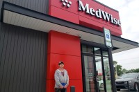 A photo of a man standing outside of a medical clinic.