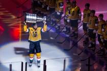 Golden Knights right wing Mark Stone (61) carries out the Stanley Cup during the raising of the ...