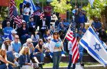 Jennifer Courier, center, holds a U.S. flag while joining others at a rally against antisemitis ...