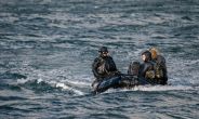 3 navy seals sitting in a boat