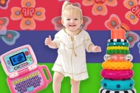 A baby standing in front of a colorful background