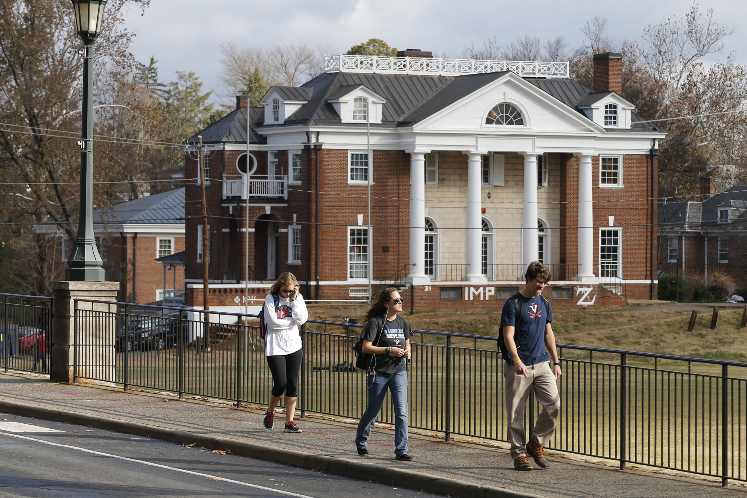 University of Virginia students walk to campus past the Phi Kappa Psi fraternity house where an alleged gang rape occurred. However, police said on Monday that they could not confirm that the rape happened.