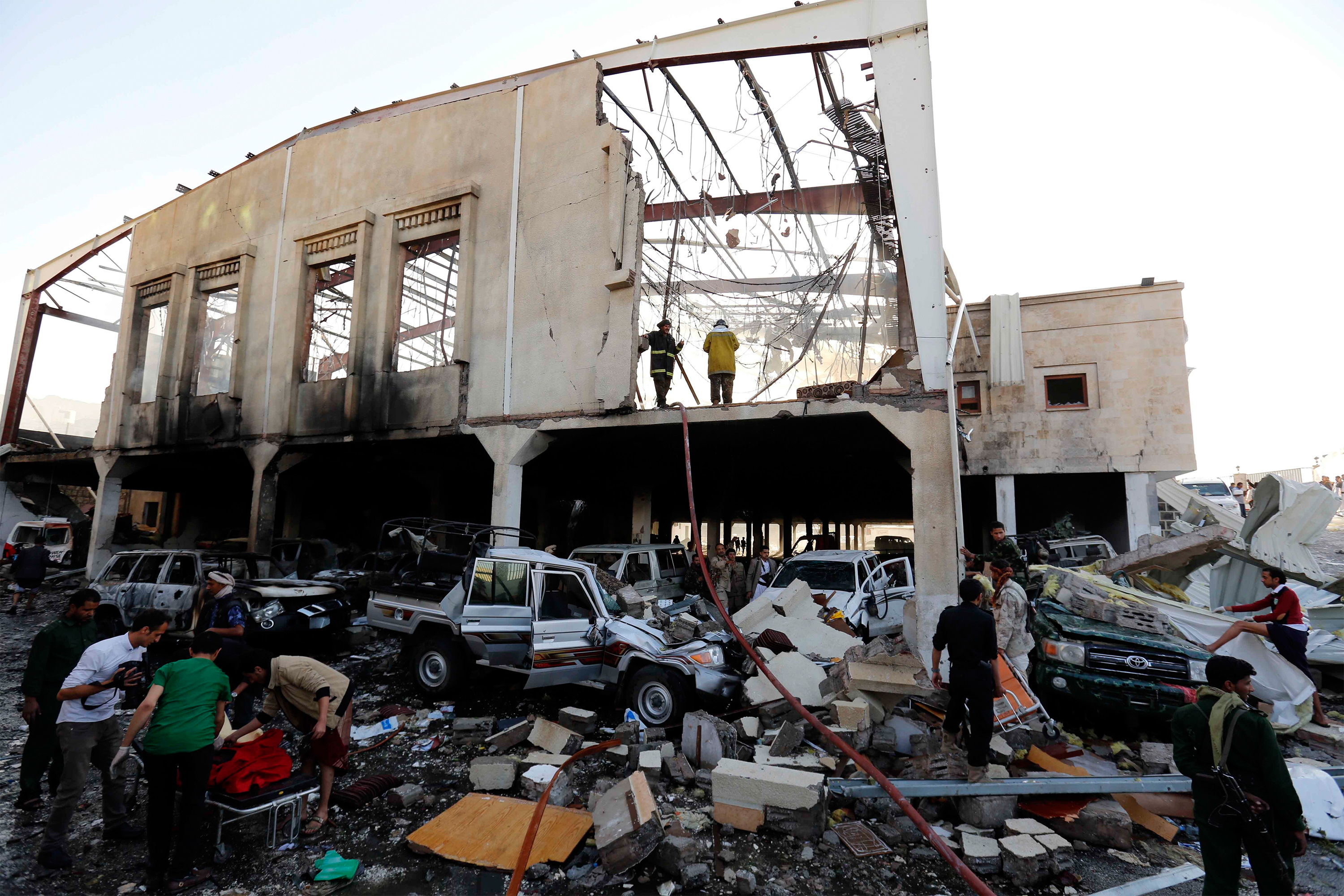 People inspect the aftermath of a Saudi-led coalition airstrike in Sanaa, Yemen, Saturday, Oct. 8