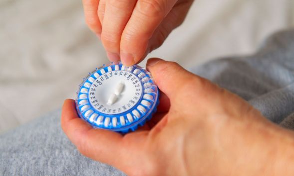 A person holding a hormone capsule.