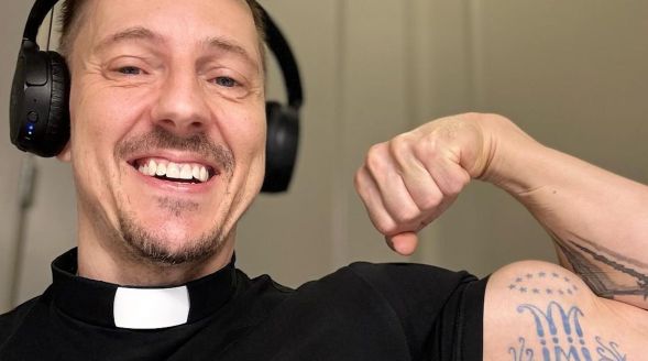 A gay priest flexing his arm