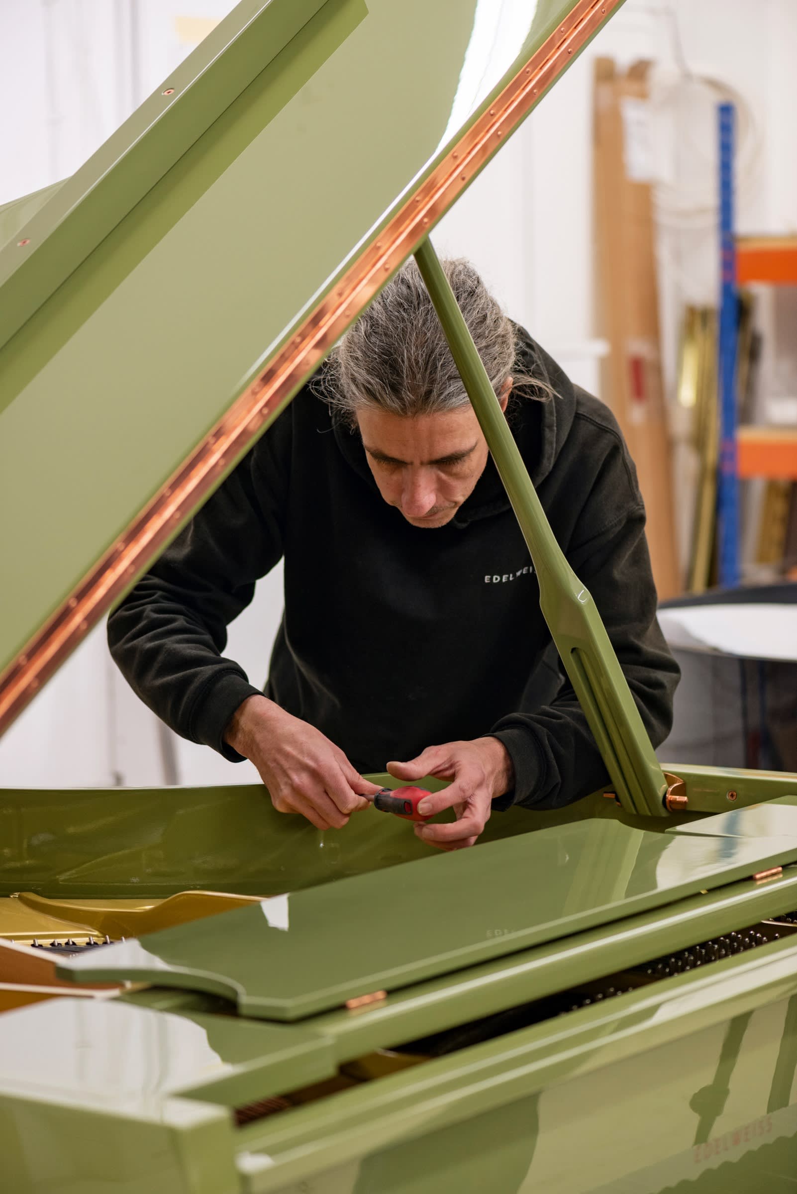 A craftsman finishes assembly on an Edelweiss piano