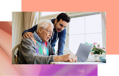 Uma pessoa olhando para um computador e conversando com um idoso