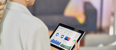 Uma pessoa segurando um tablet exibindo gráficos e gráficos coloridos, indicando análise de dados ou métricas de negócios.