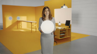 Uma mulher segurando uma bola branca em um escritório.