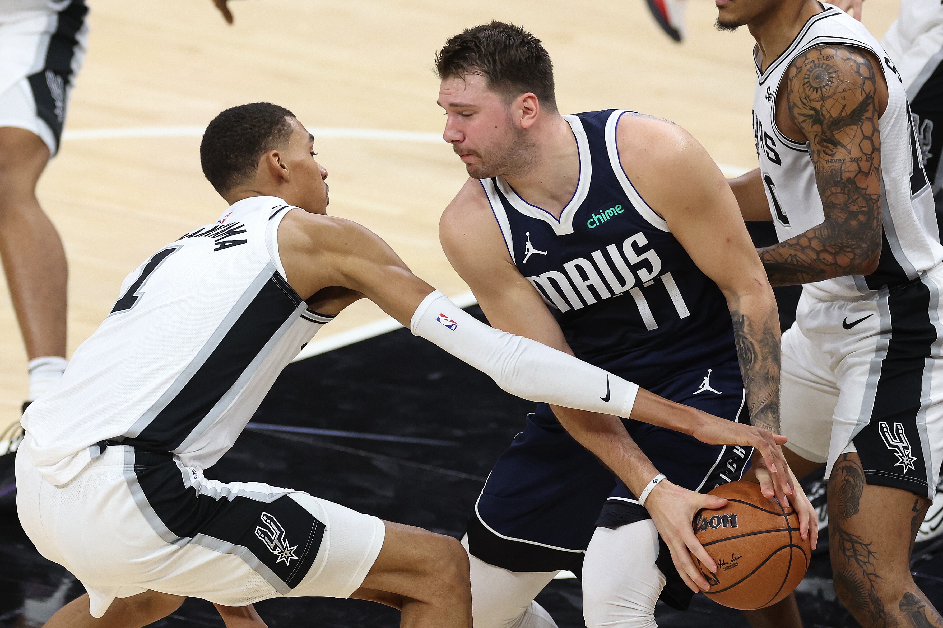 Victor Wembanyama tries to snatch the ball from Luka Dončić during Wednesday's match.