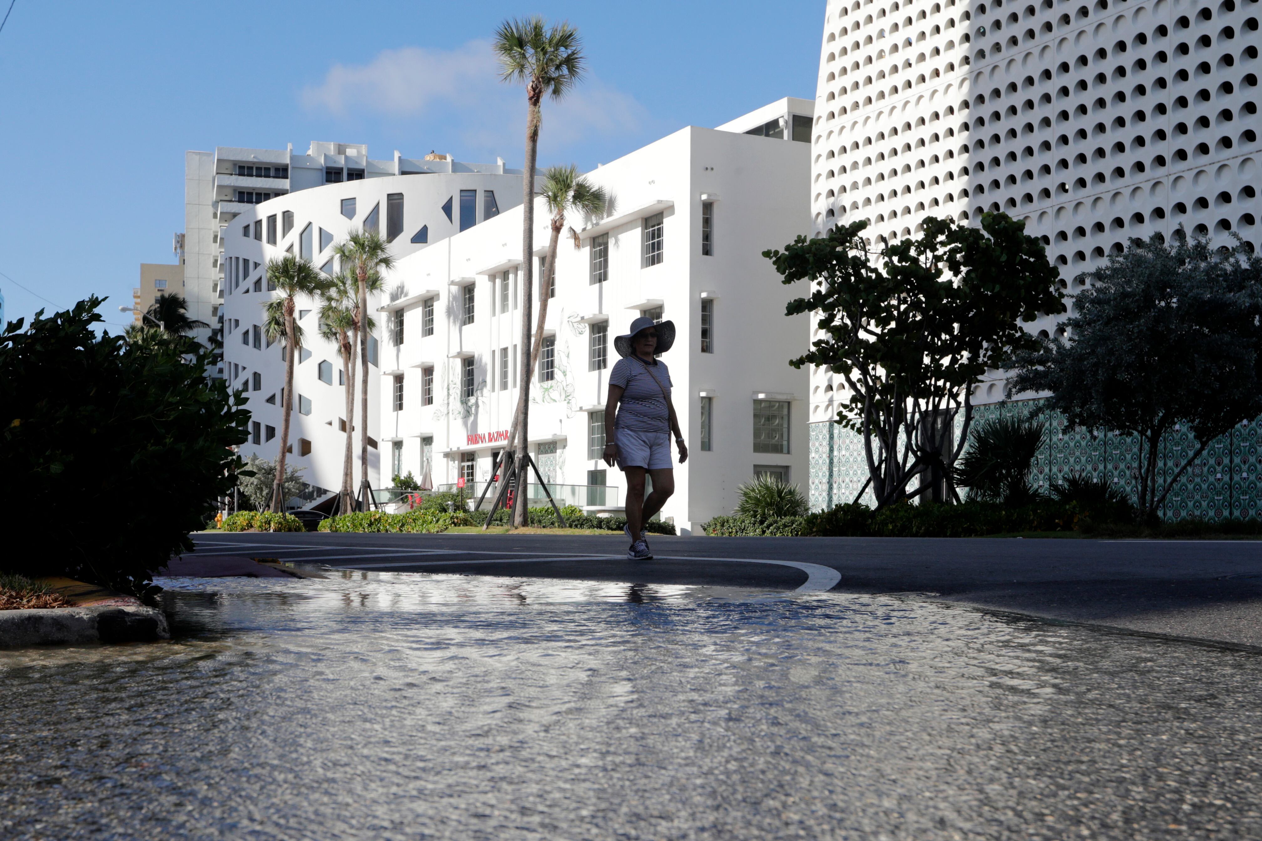 A woman walks along a flooded street in Miami Beach.