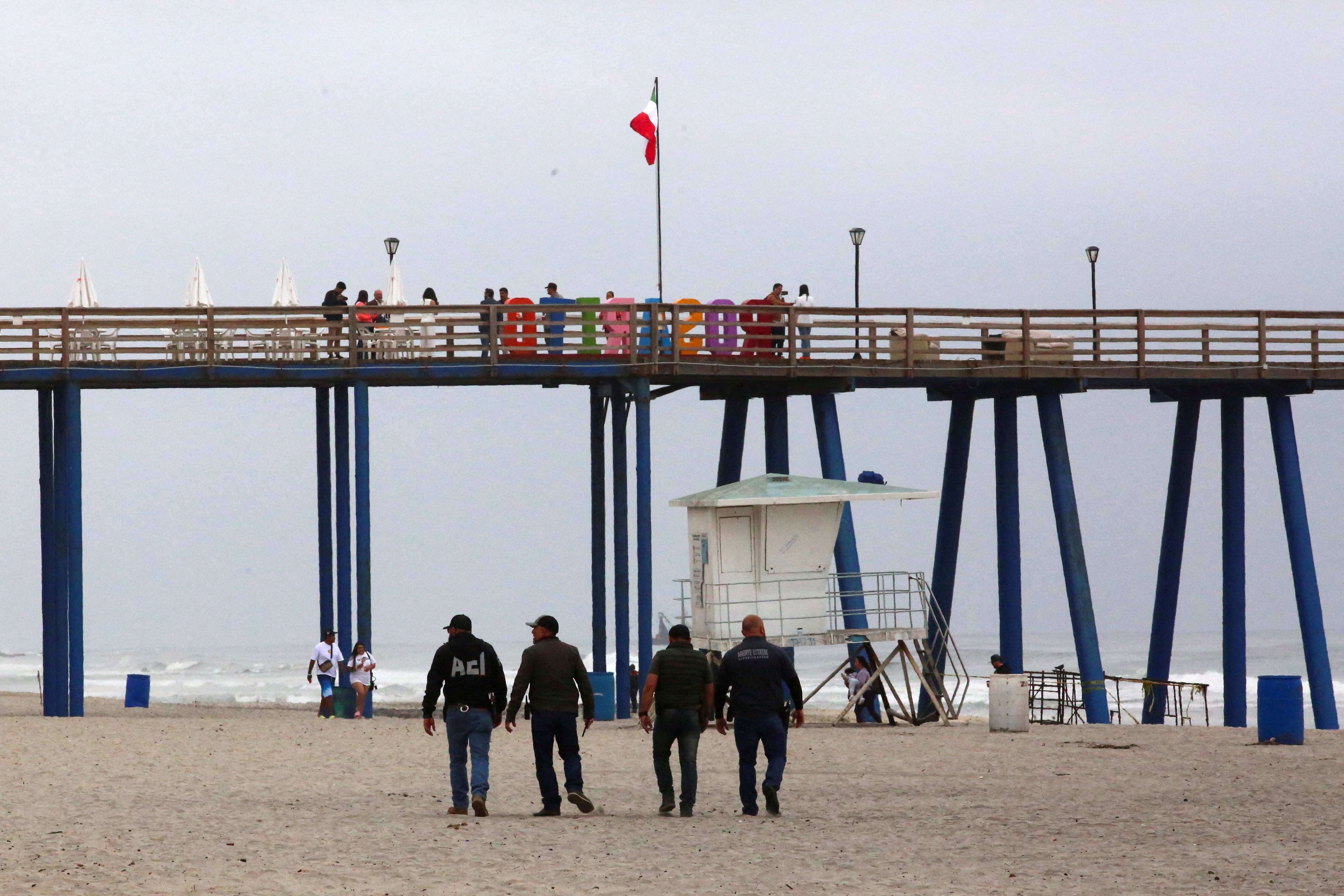 Security agents walk along Rosarito beach after the disappearance of the three foreign tourists in Baja California on May 2.