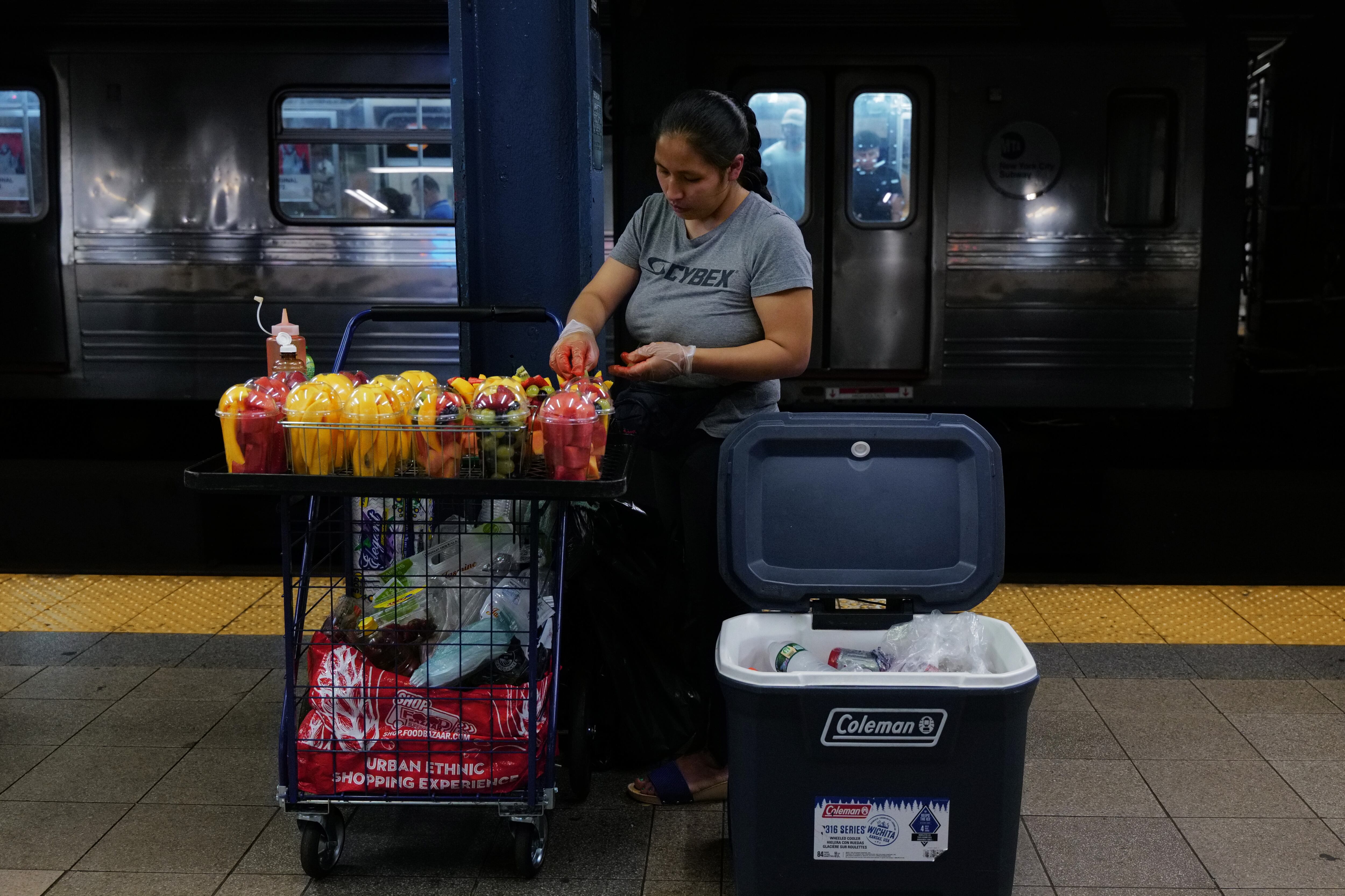 A woman selling fruit and other items at a New York subway station on August 18, 2023 in New York