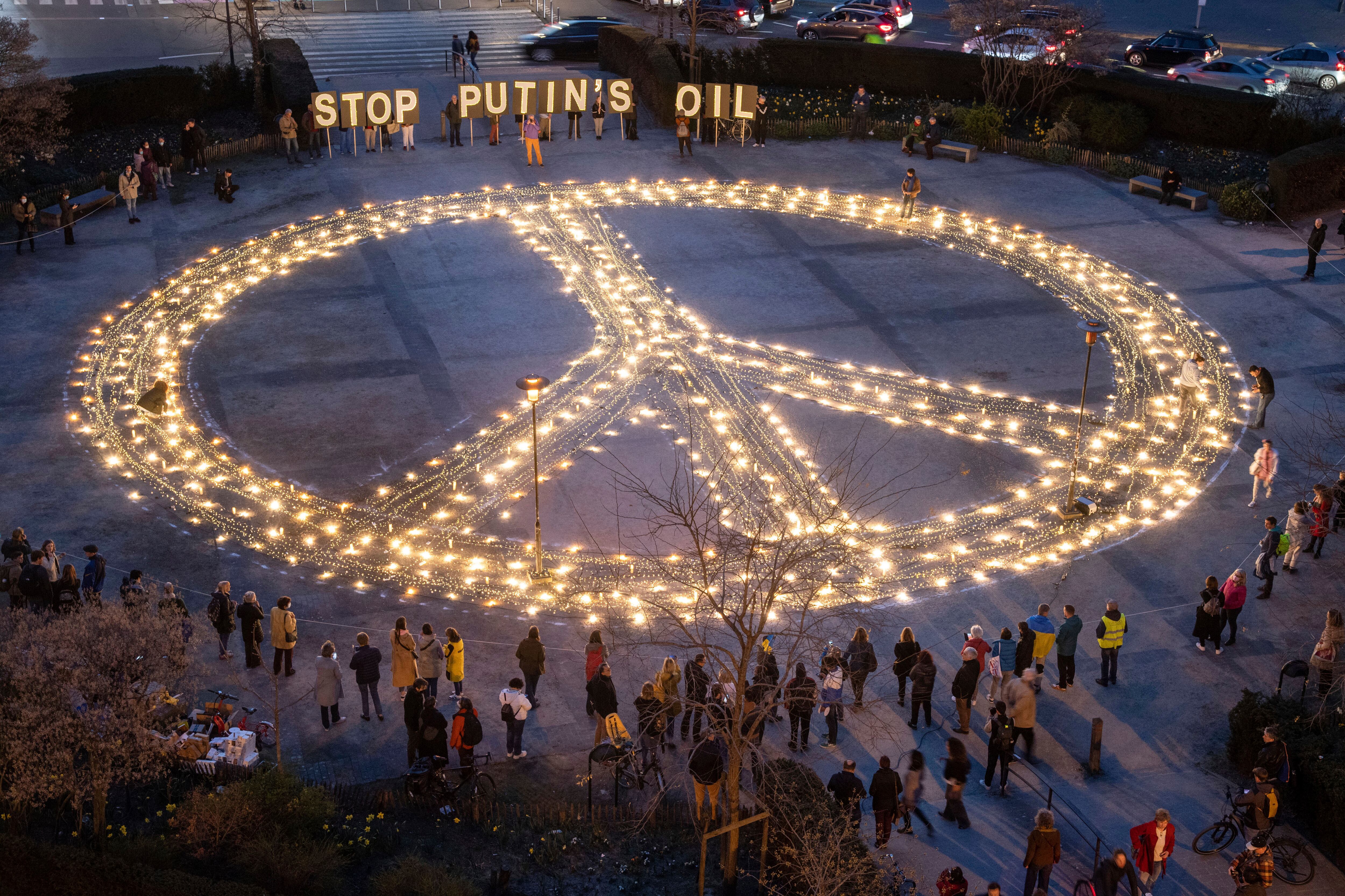 Manifestantes protestan ante un cartel de la paz antes de una cumbre de la UE y la OTAN en Bruselas, el martes 22 de marzo de 2022.