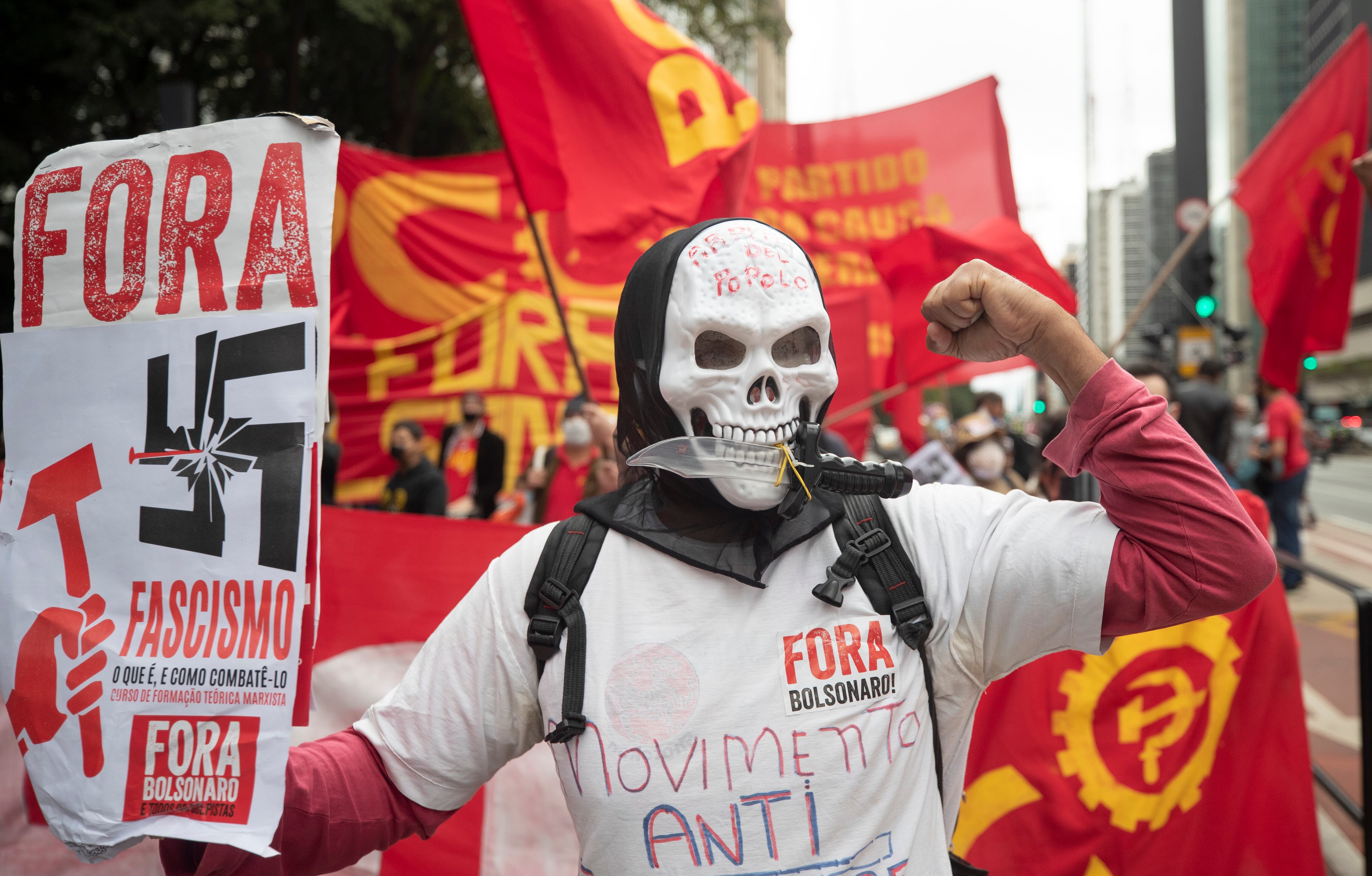 Un manifestante sostiene un cartel que dice en portugués `Fuera el fascismo' durante una protesta contra Jair Bolsonaro, en Brasil, en 2020.