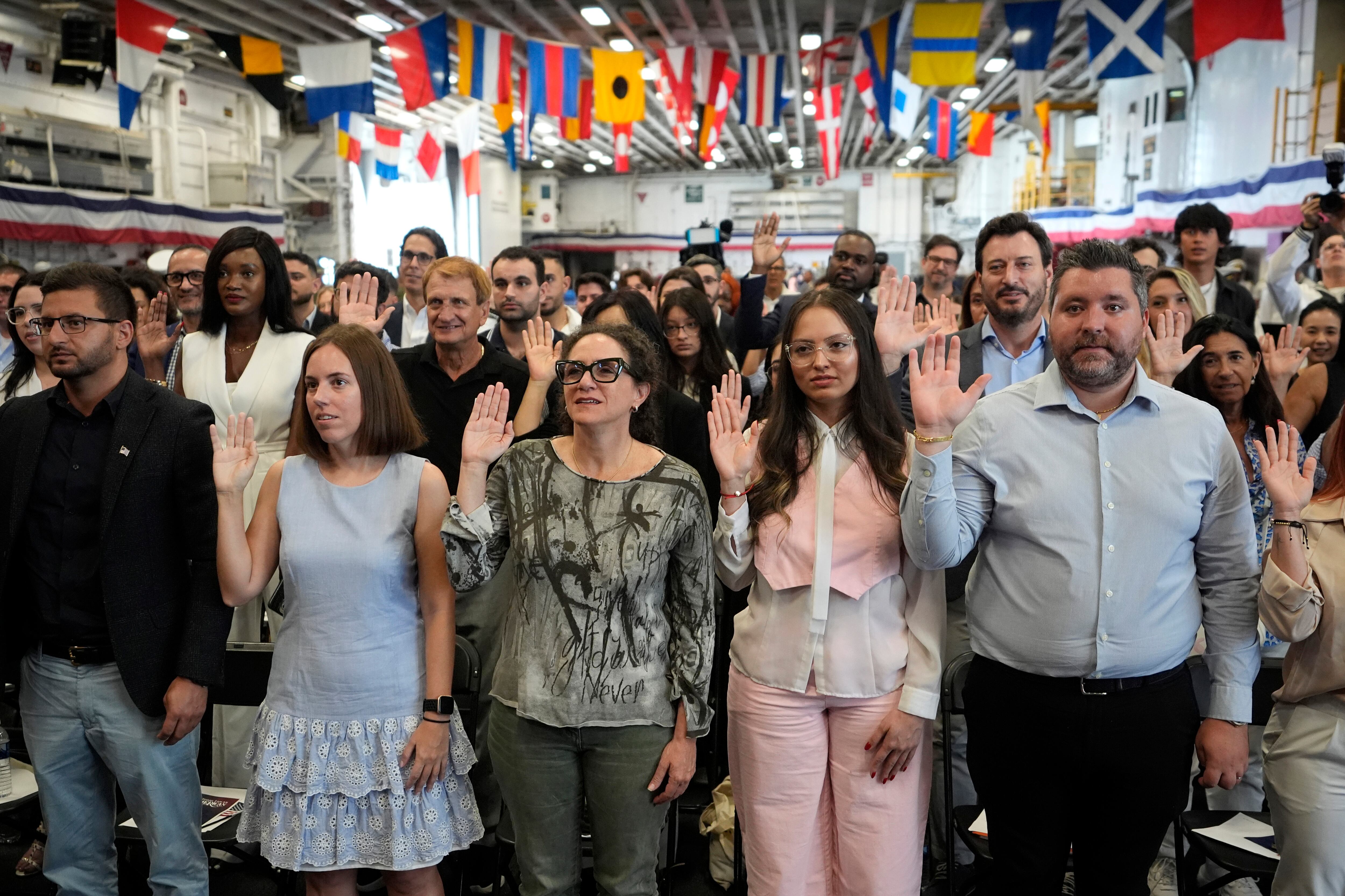 People are sworn in during their naturalization ceremony aboard the USS Bataan in Miami, Florida, May 7.