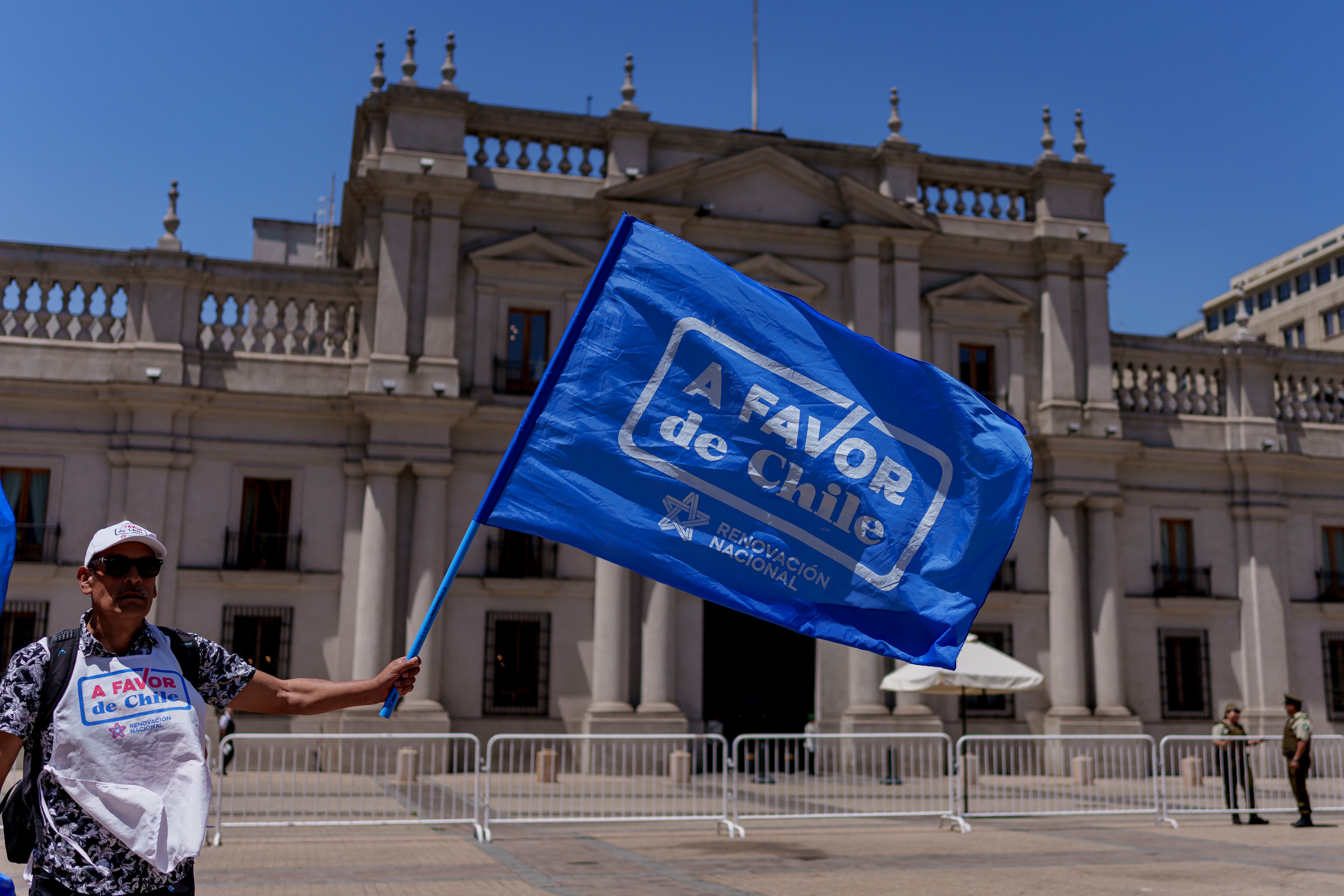 Un hombre ondea una bandera de la campaña por la opción 'a favor', el 6 de diciembre frente a La Moneda.