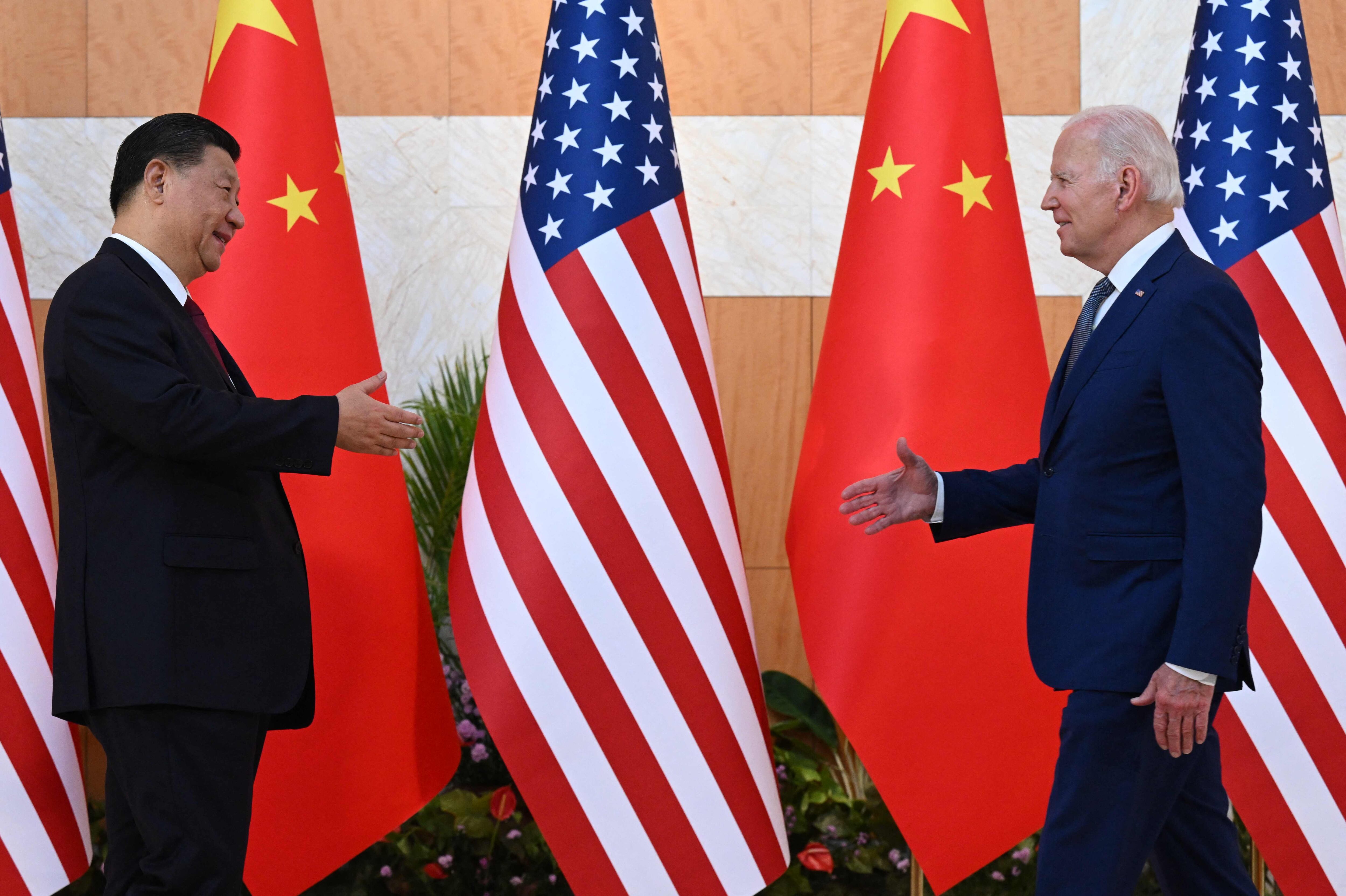 President Joe Biden and China's President Xi Jinping walk to shake hands as they meet on the sidelines of the G20 Summit in Nusa Dua on the Indonesian resort island of Bali on November 14, 2022.