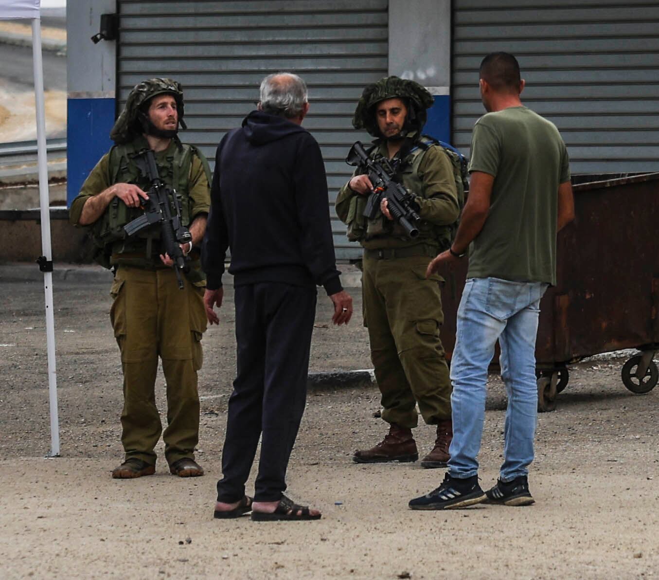 Two Israeli soldiers and two Palestinians, on the main road in the West Bank town of Huwara, last November.