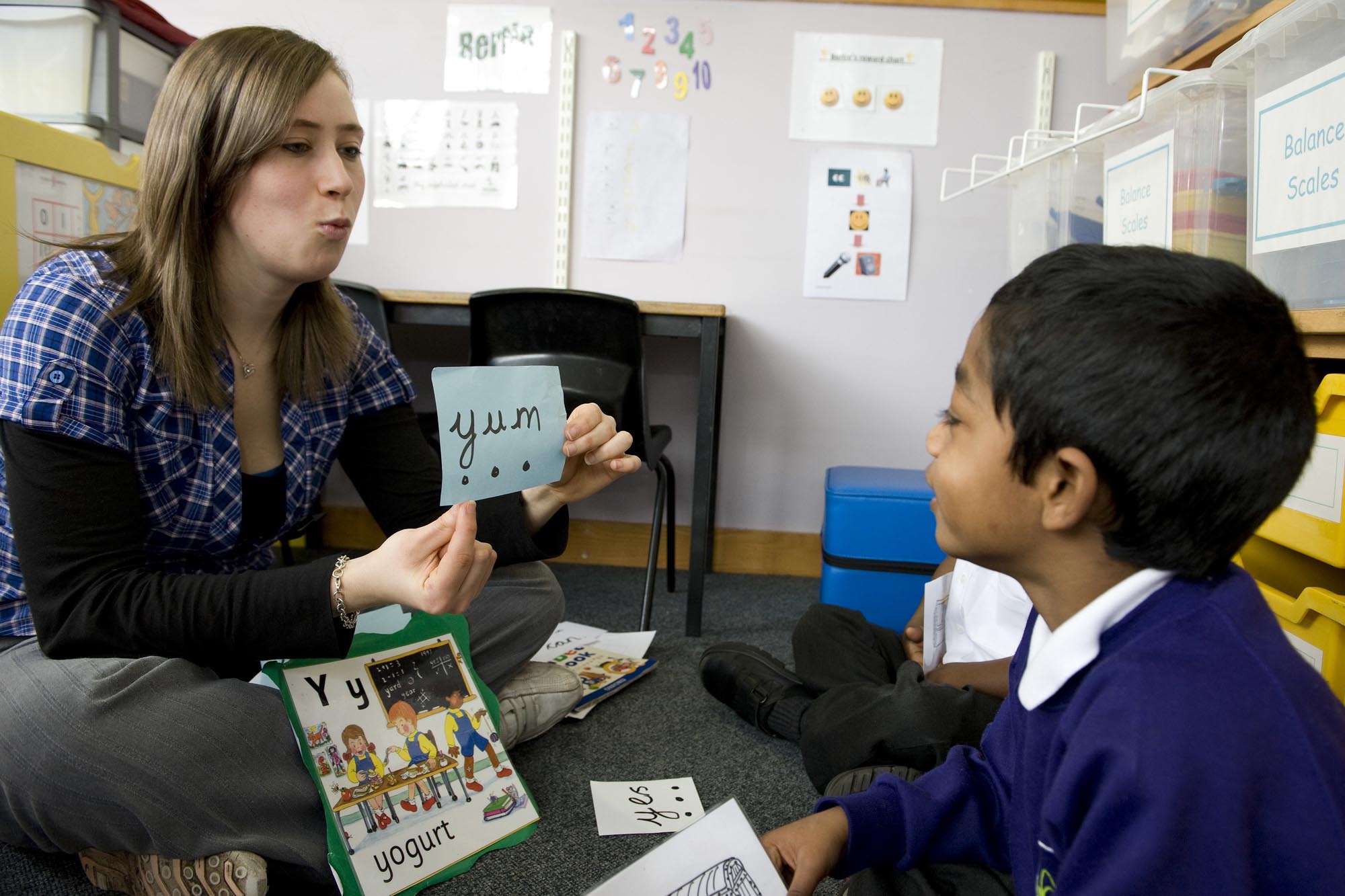 A teacher practices phonics with a young student.