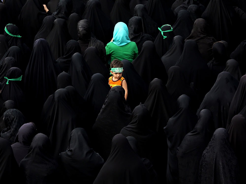 A child looks on as Iranian mourners attend the funeral of three members of the Islamic Republic's Revolutionary Guards reportedly killed in Syria, on June 25, 2015, in Tehran.