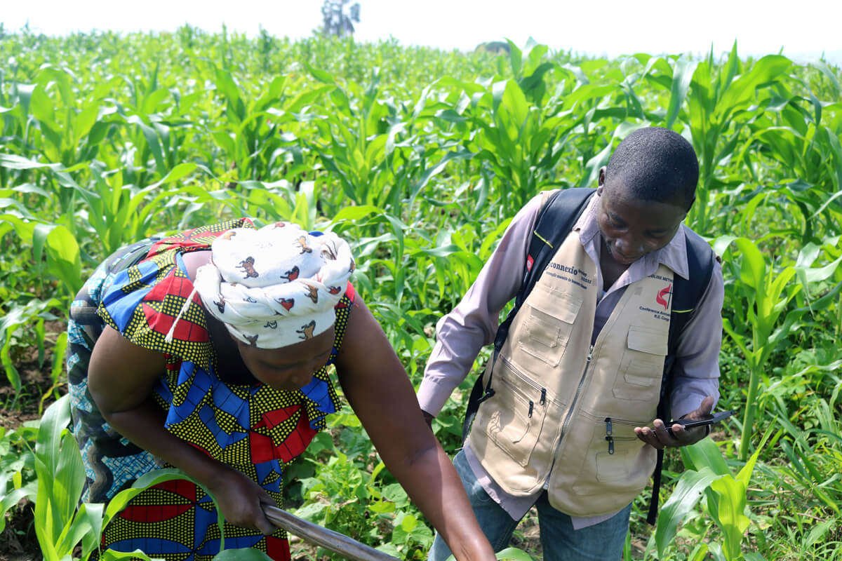 Chantal Naweza (left) weeds a community garden in the Ubwari region of eastern Congo. A project of The United Methodist Church, the community field fosters peaceful cohabitation and enables local community members to cope with economic problems. Photo by Philippe Kituka Lolonga, UM News.