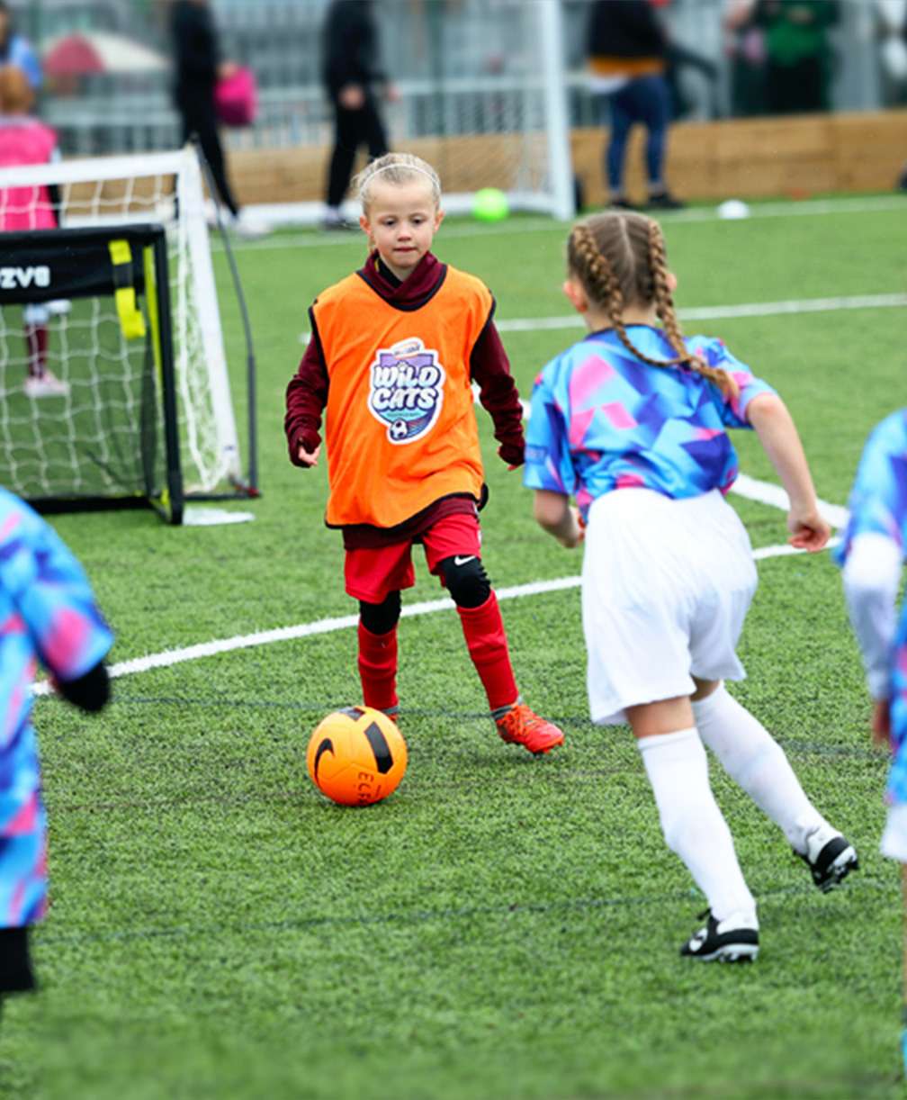 A young girl receives a pass during a small-sided game at a Wildcats training session.