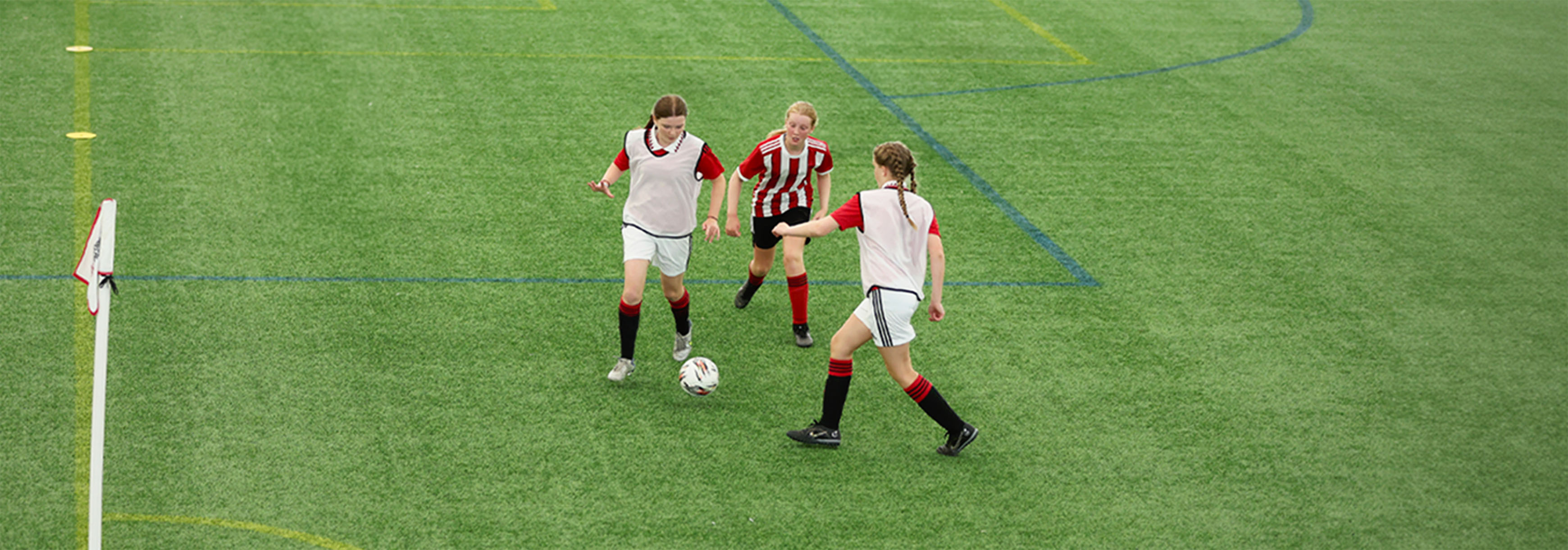 Two attackers combine out wide while a defender approaches to press the player in possession. 