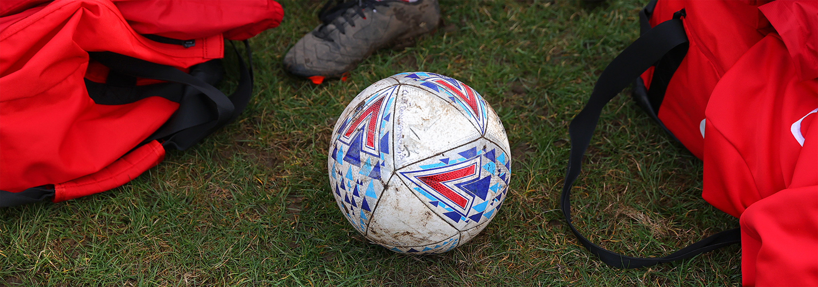 A football placed on a grass pitch.