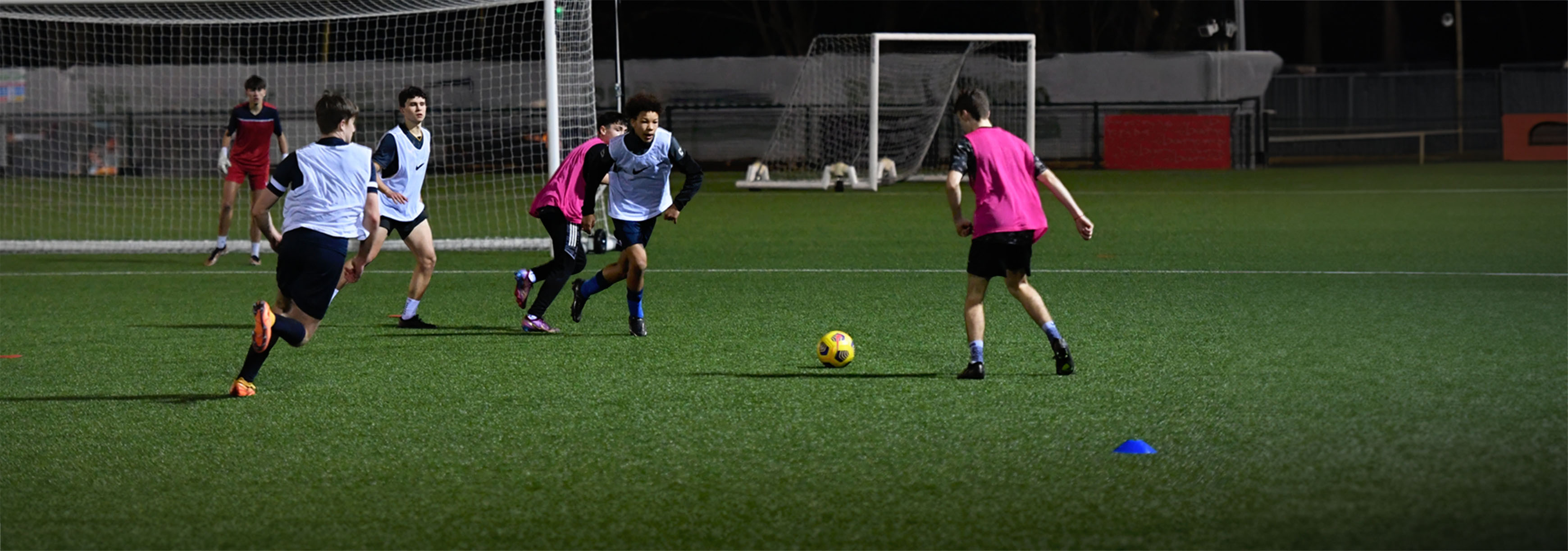 During a training session, a player makes a run in between two defenders in the hope of receiving a pass from his teammate out wide.