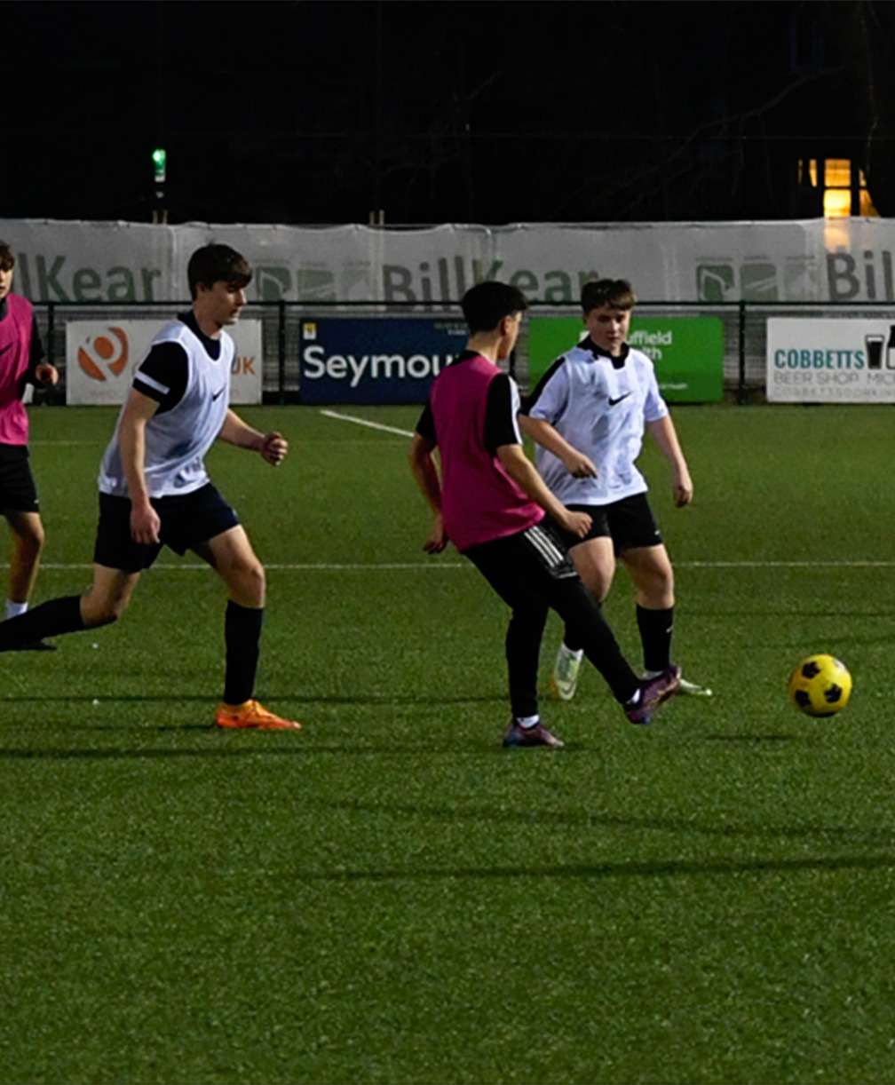 A group of players taking part in a passing practice in training.