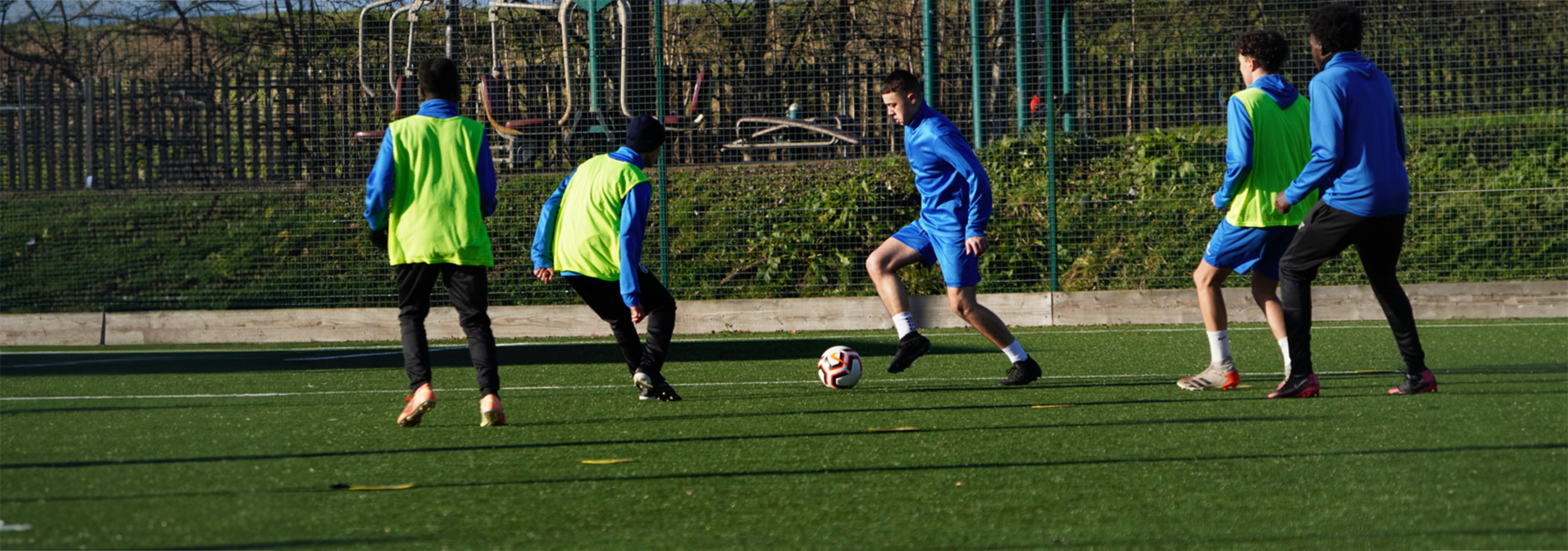 During a small-sided game in training, a player prepares to make a front foot pass as an opponent goes to close him down.