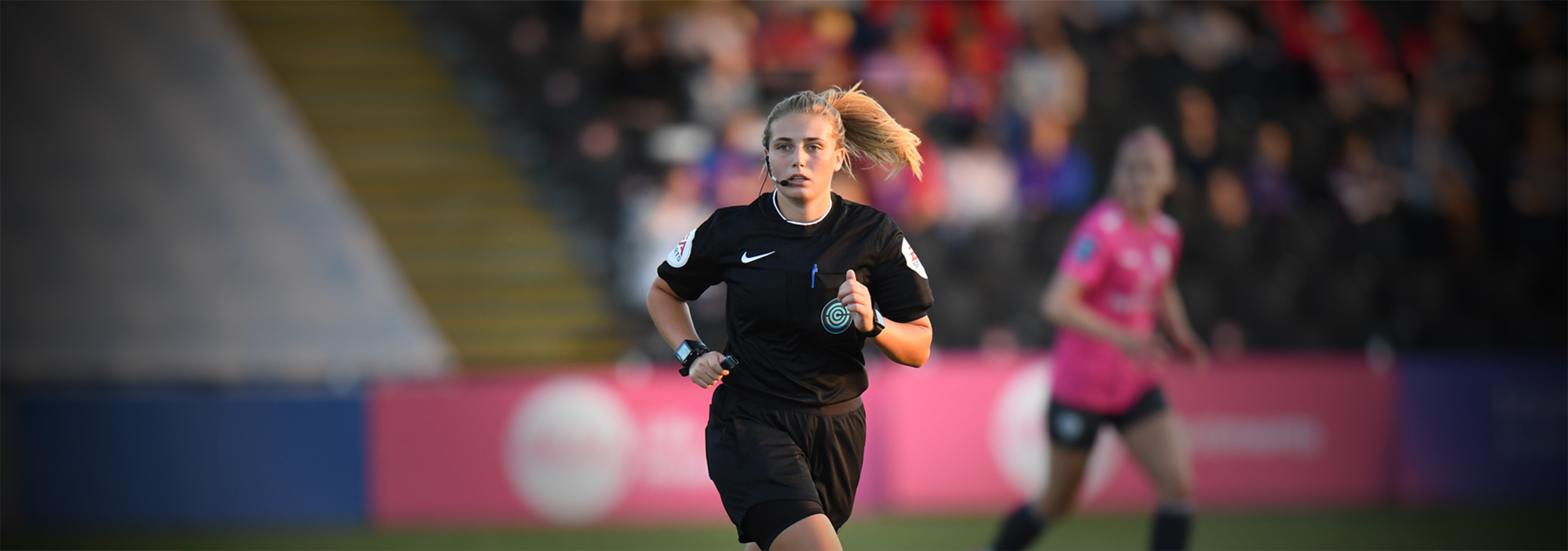 A female referee running during a match