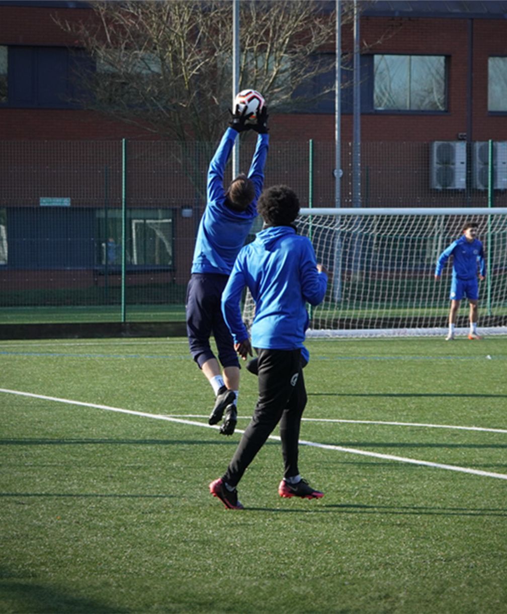 Goalkeeper jumps to catch the ball above him