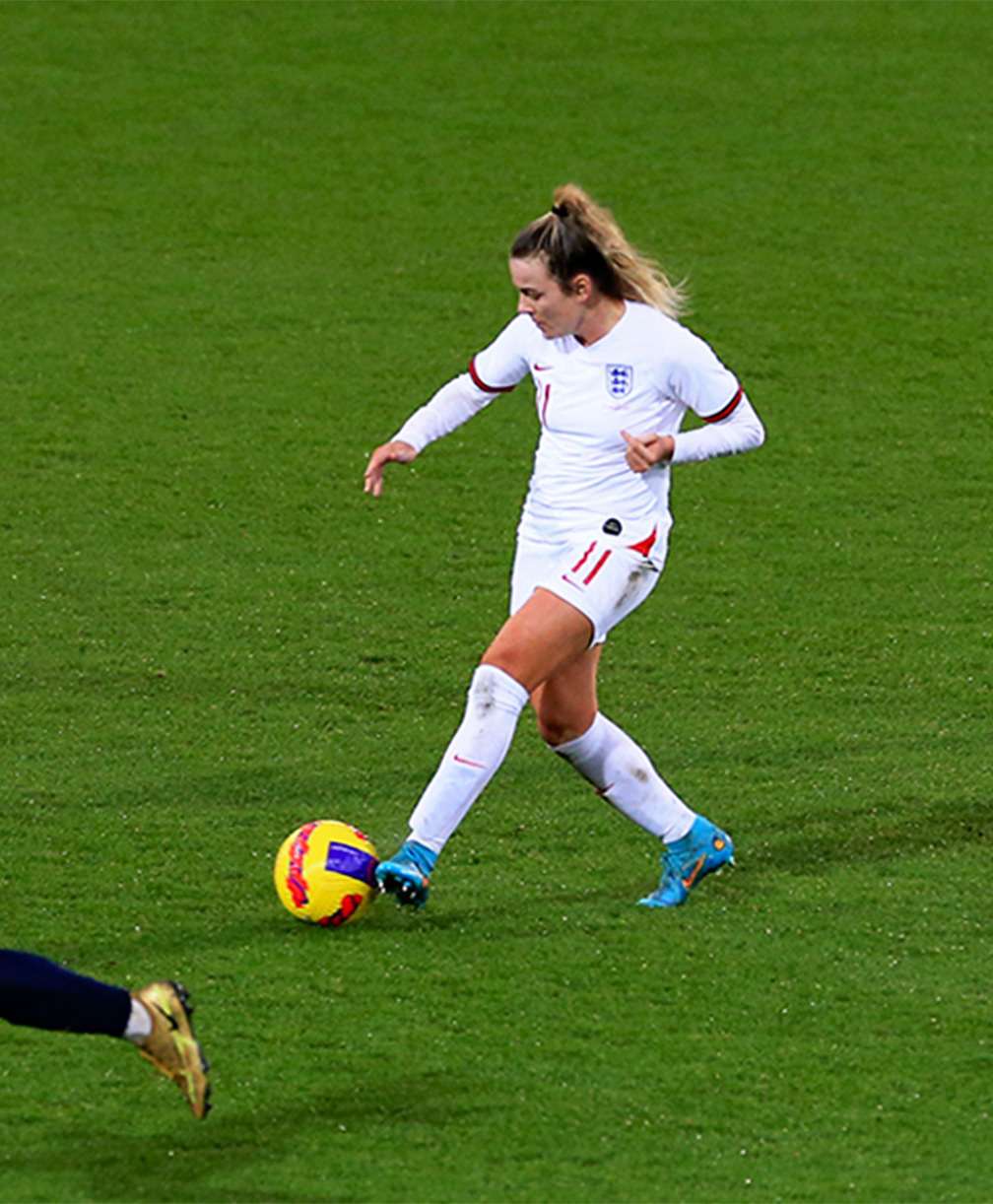 A member of the England womans team passes the ball during a match