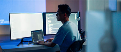 A person sitting at a desk and working on laptop