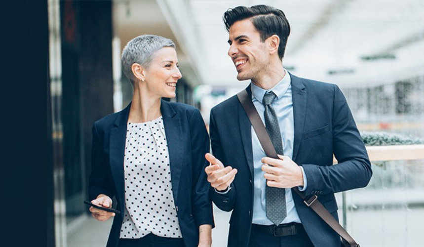 Two businesspersons walking together and talking.