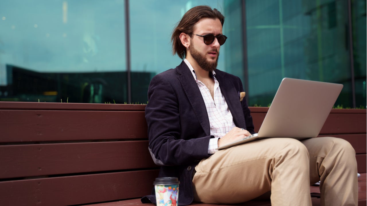 Man works on laptop outside