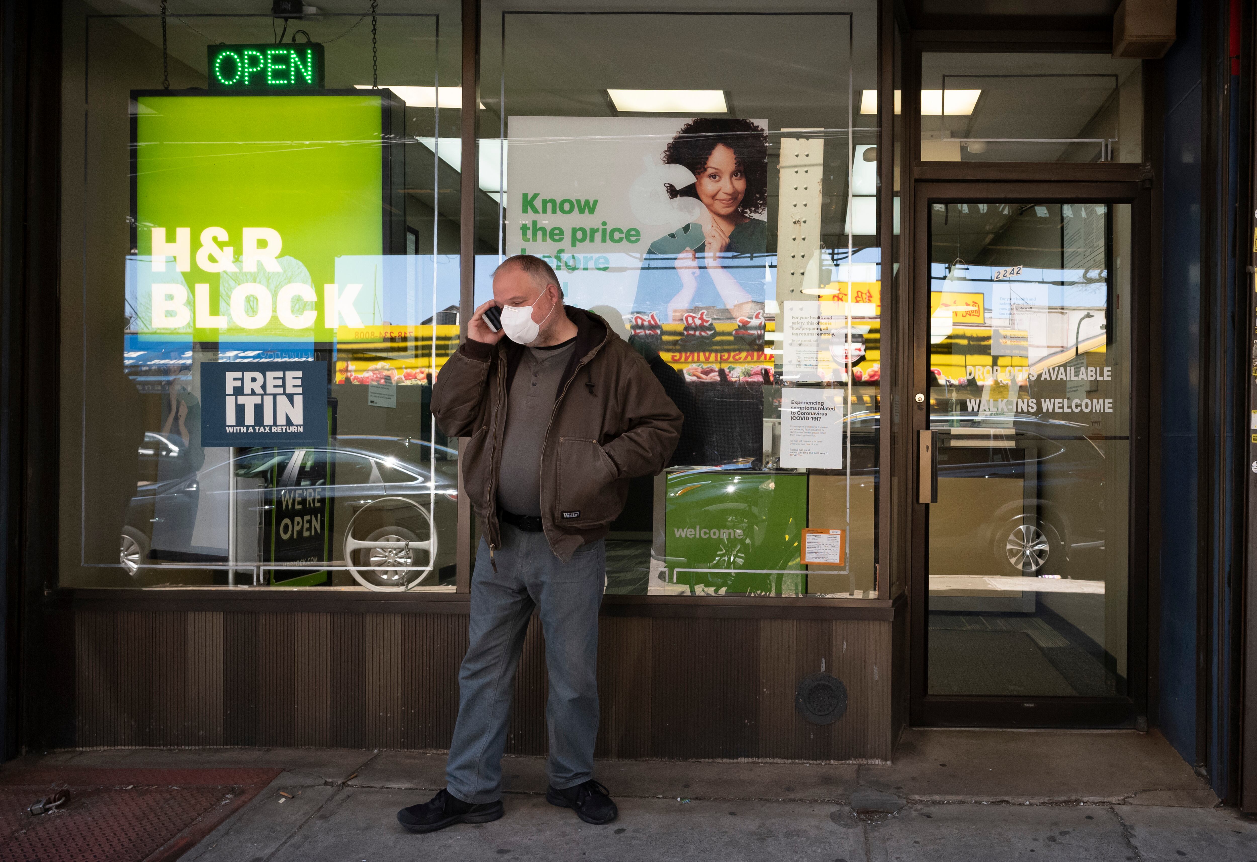 A man waits outside a H&R Block tax preparation office on Monday, April 6, 2020, in the Brooklyn borough of New York. Tax season is here again.