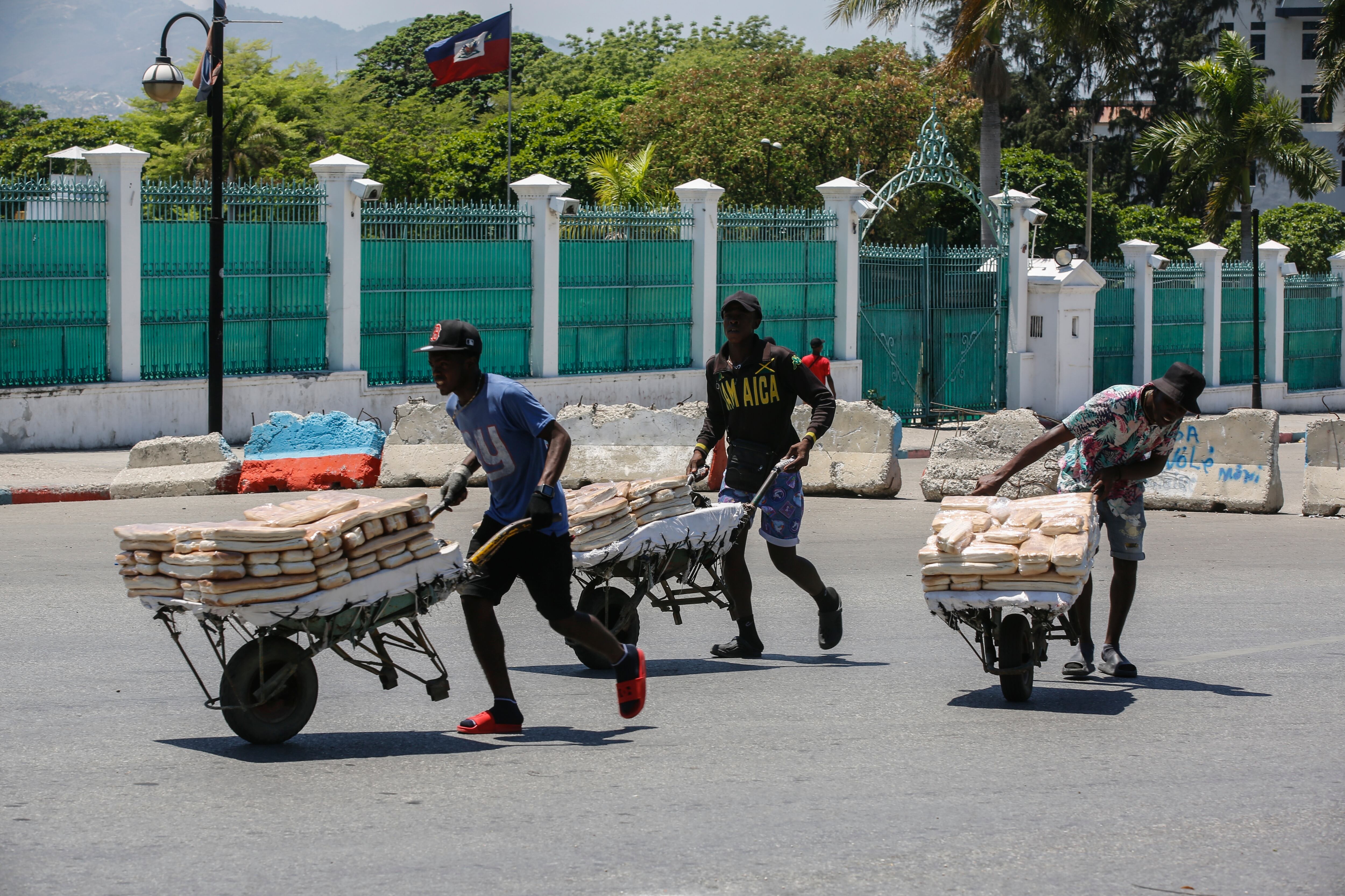Street vendors withdraw from the area where they were selling their bread, near the National Palace, in Port-au-Prince, Haiti, Tuesday, April 2, 2024. (AP Photo/Odelyn Joseph)