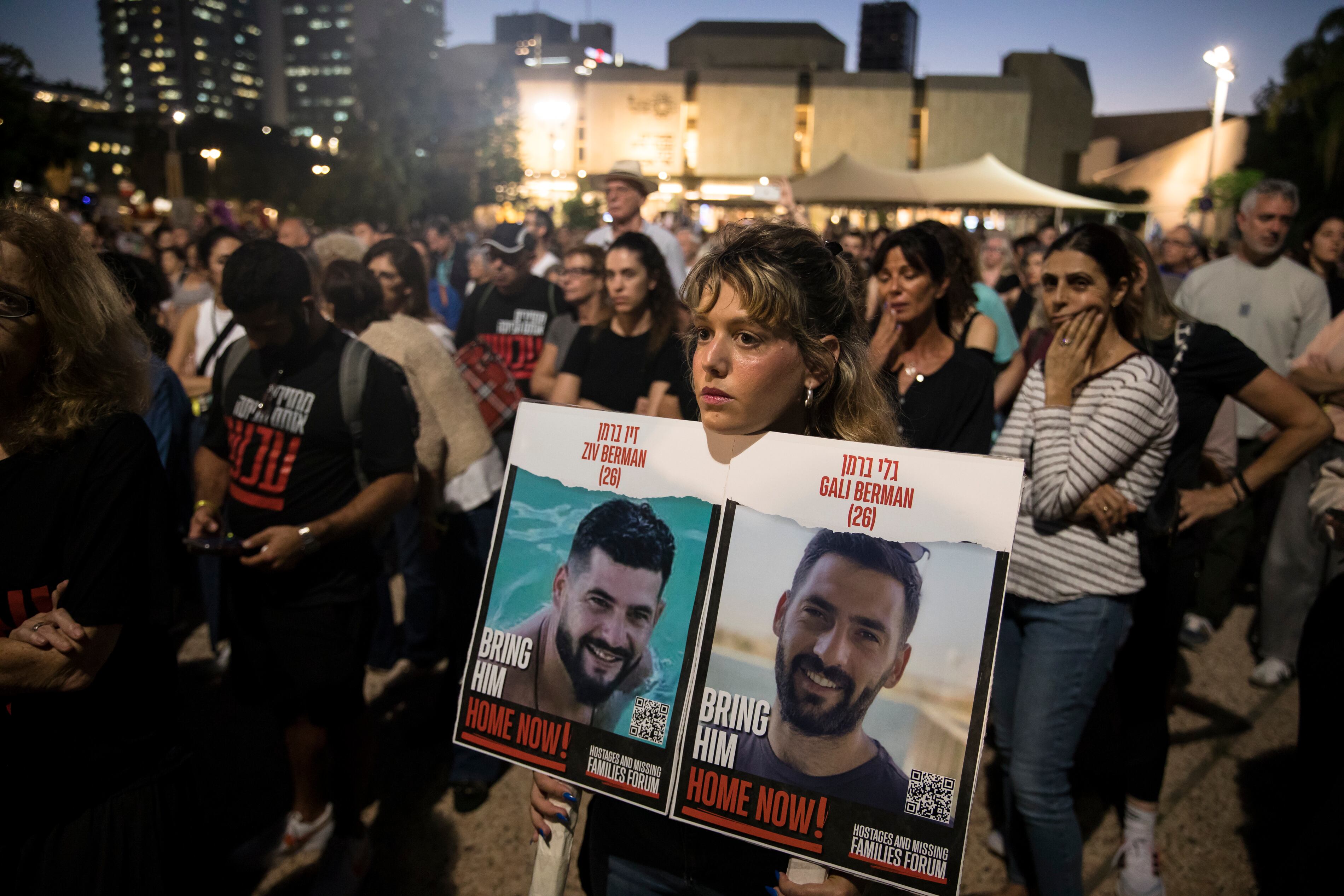 A woman holds a photo of hostages who were kidnapped and taken to the Gaza Strip following the Hamas attack on October 7, Tuesday, November 7, 2023, in Tel Aviv.