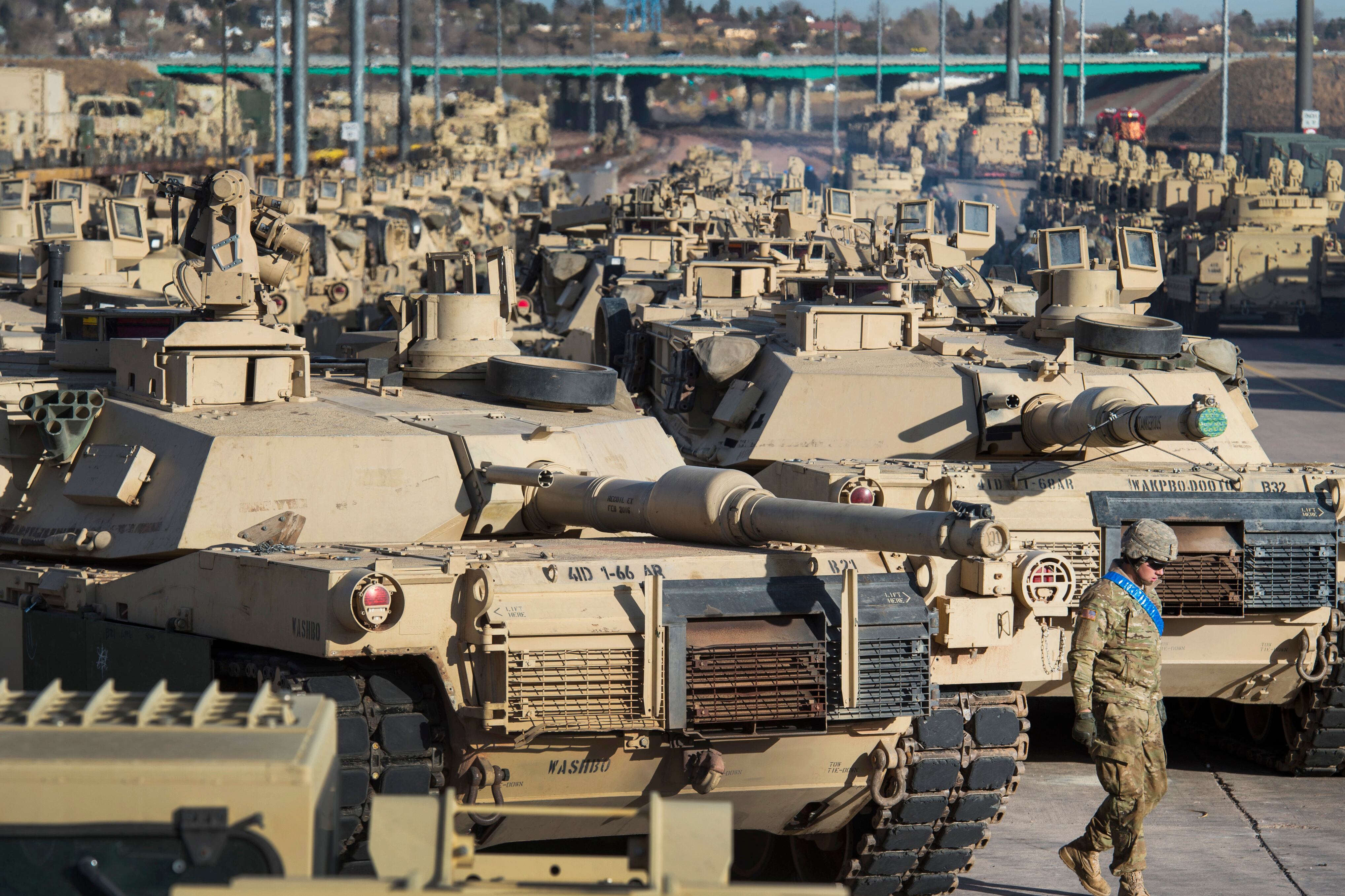 A soldier walks past a line of M1 Abrams tanks, Nov. 29, 2016, at Fort Carson in Colorado Springs, Colo.